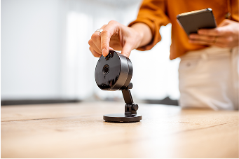 Person grasping sercurity camera